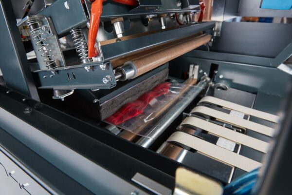 TH44 Heat sealing machine for the plastic bags that contains the folded garments. 